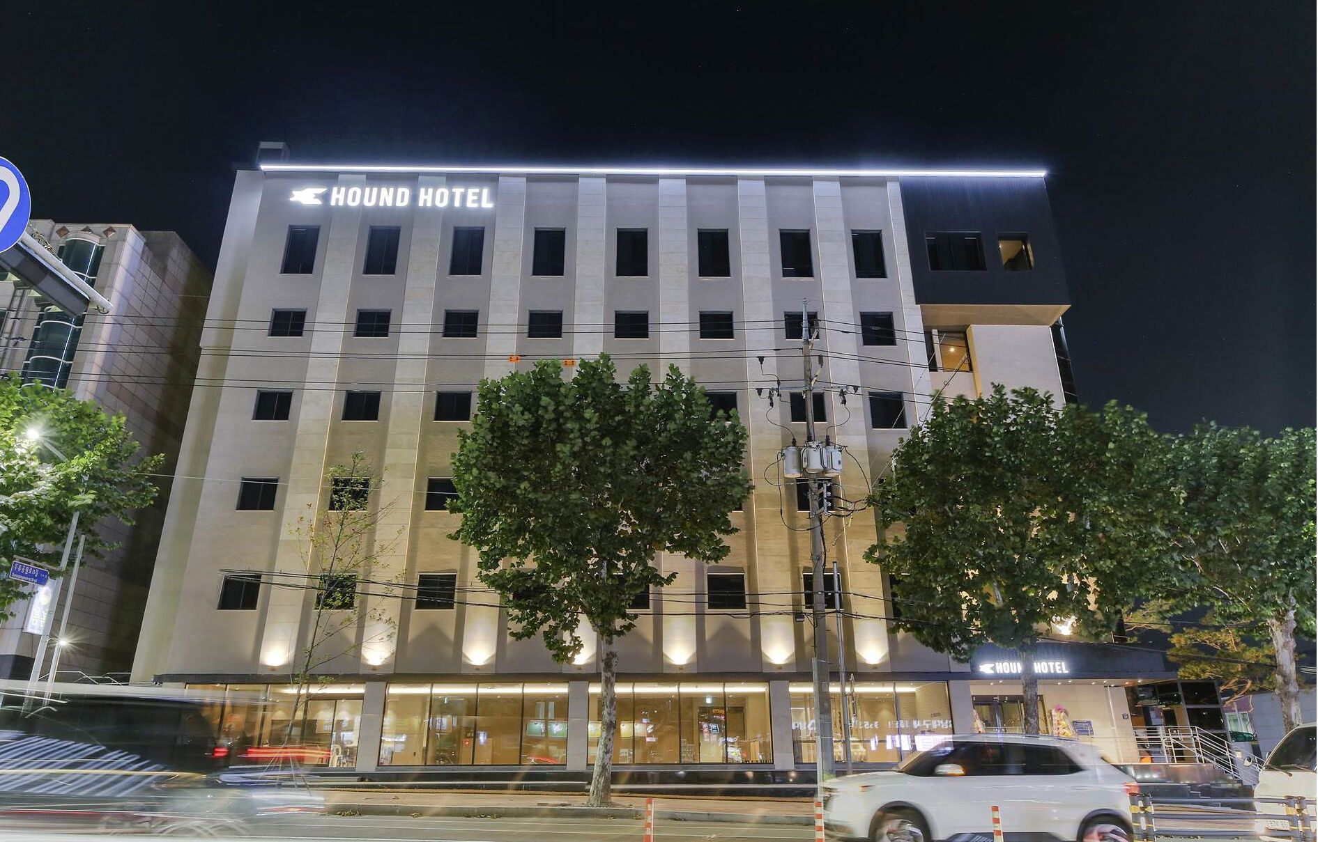 Un edifici modern d'hotel amb un cartell ben visible que diu 