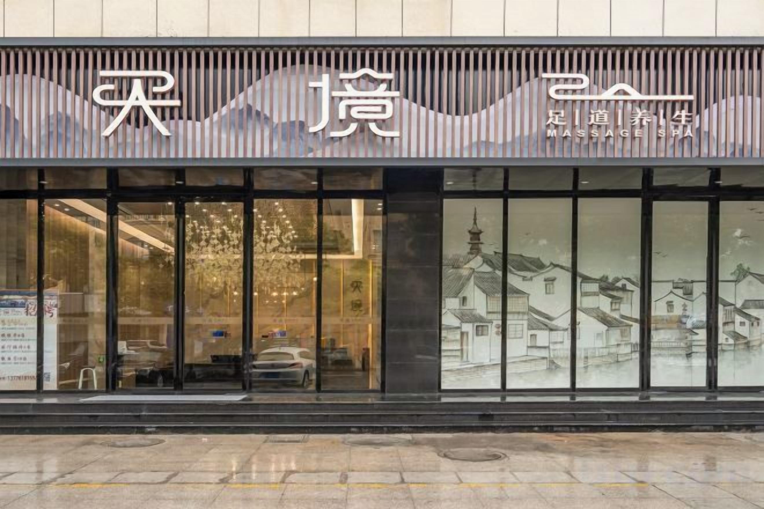 Un edificio con ventanas grandes y un letrero que dice 'MASSAGE SHA'.