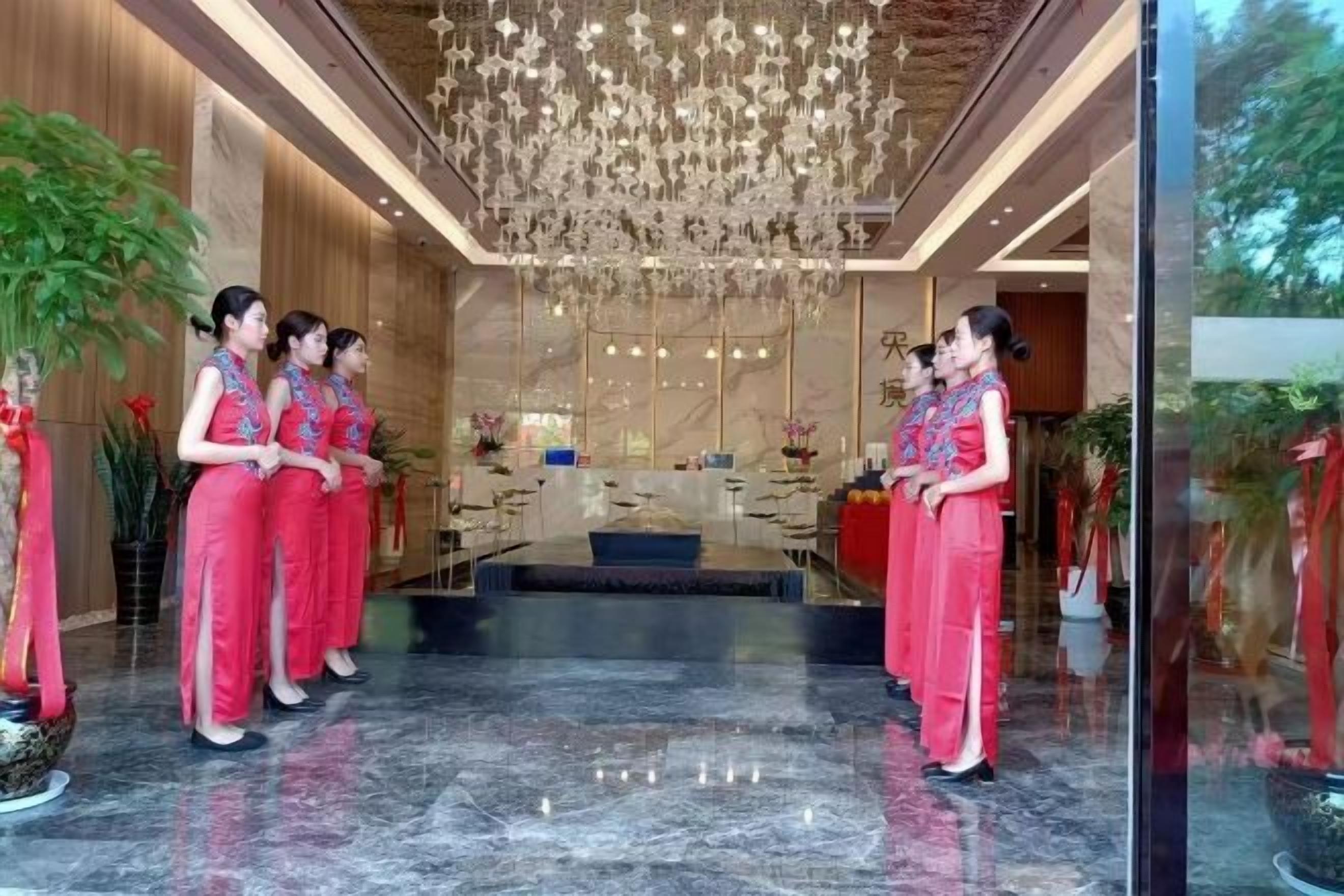 A reception area with a chandelier, a reception desk, and a seating area.