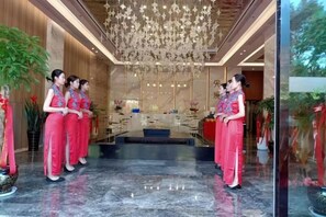 A reception area with a chandelier, a reception desk, and a seating area. - Yurong International Hotel (Kunshan)