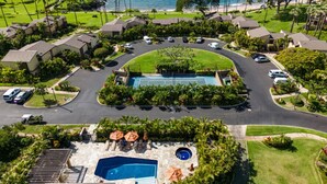 Vue aérienne d’un complexe hôtelier doté d’une piscine, de courts de tennis et d’une plage.