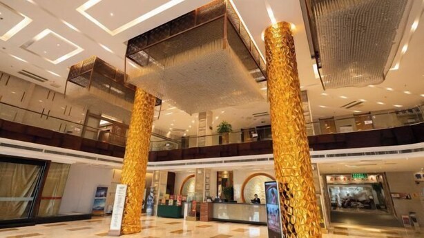 A spacious lobby with a high ceiling, a reception desk, and a staircase. - Jinshui Hot Spring Hotel (Shen County)