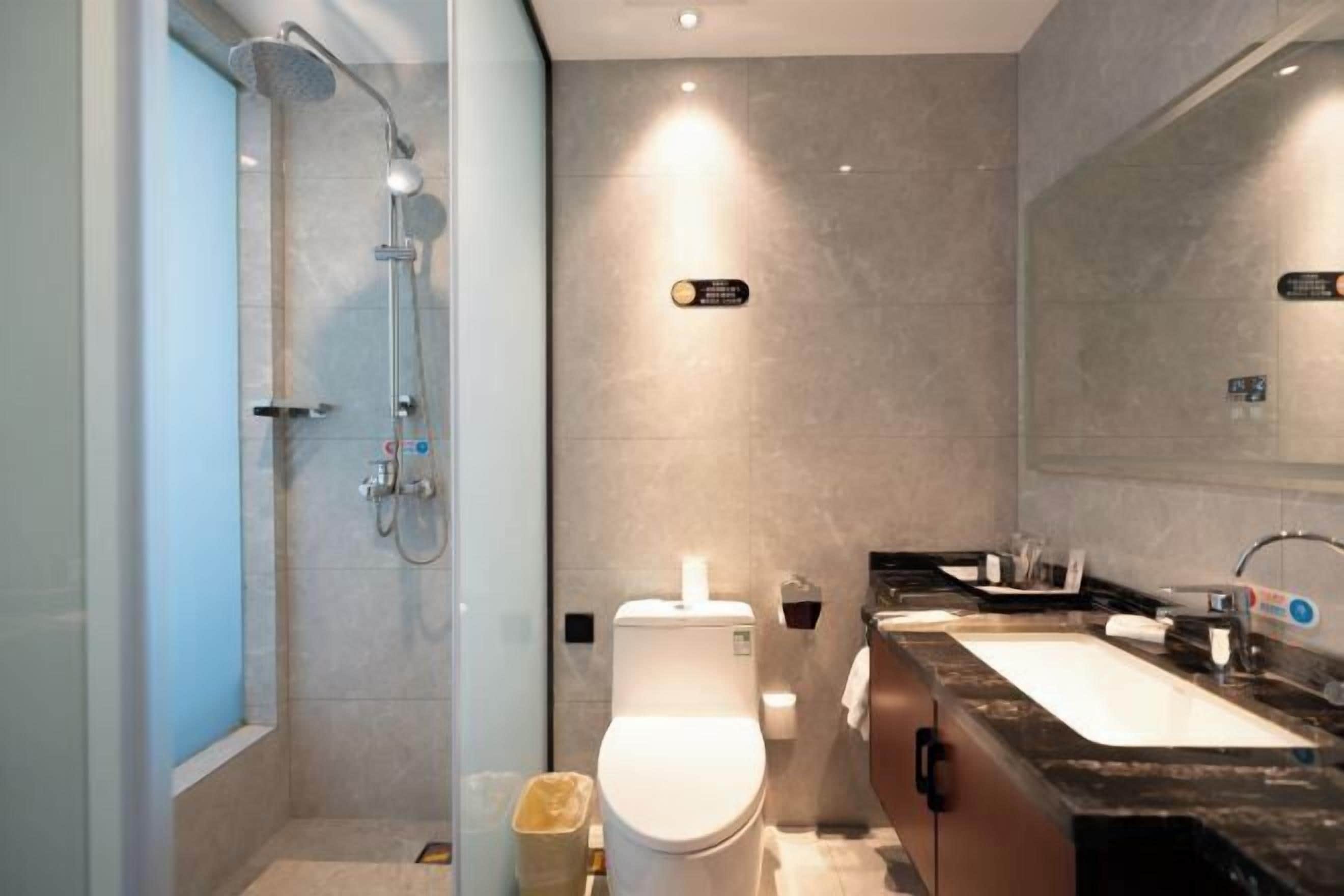 A modern bathroom with a shower, toilet, and dual sinks.