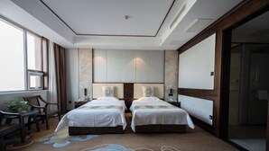A hotel room with two beds, a desk, and a chair. - Jinshui Hot Spring Hotel (Shen County)