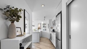 A modern kitchen with white cabinetry, a central island, and a built-in oven.