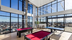 A high-rise building with multiple pool tables and a city view.