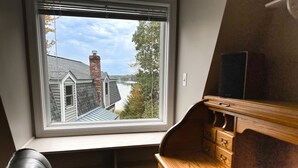 A room with a view of a house through a window, a desk with drawers, and a chair. - Waterfront Oasis~Pool Table~Deck~Dock~Garage (Dover)