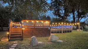 A deck with string lights, a covered seating area, and a satellite dish. - CDNH Villa at Katy Lake (Katy)
