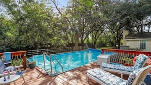 A backyard with a swimming pool, wooden deck, lounge chairs, and a fenced area. - CDNH Villa at Katy Lake (Katy)