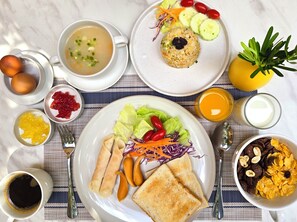 A breakfast table with various dishes including soup, fried rice, salad, and toast. - Hotel Bangkokian (Bangkok)