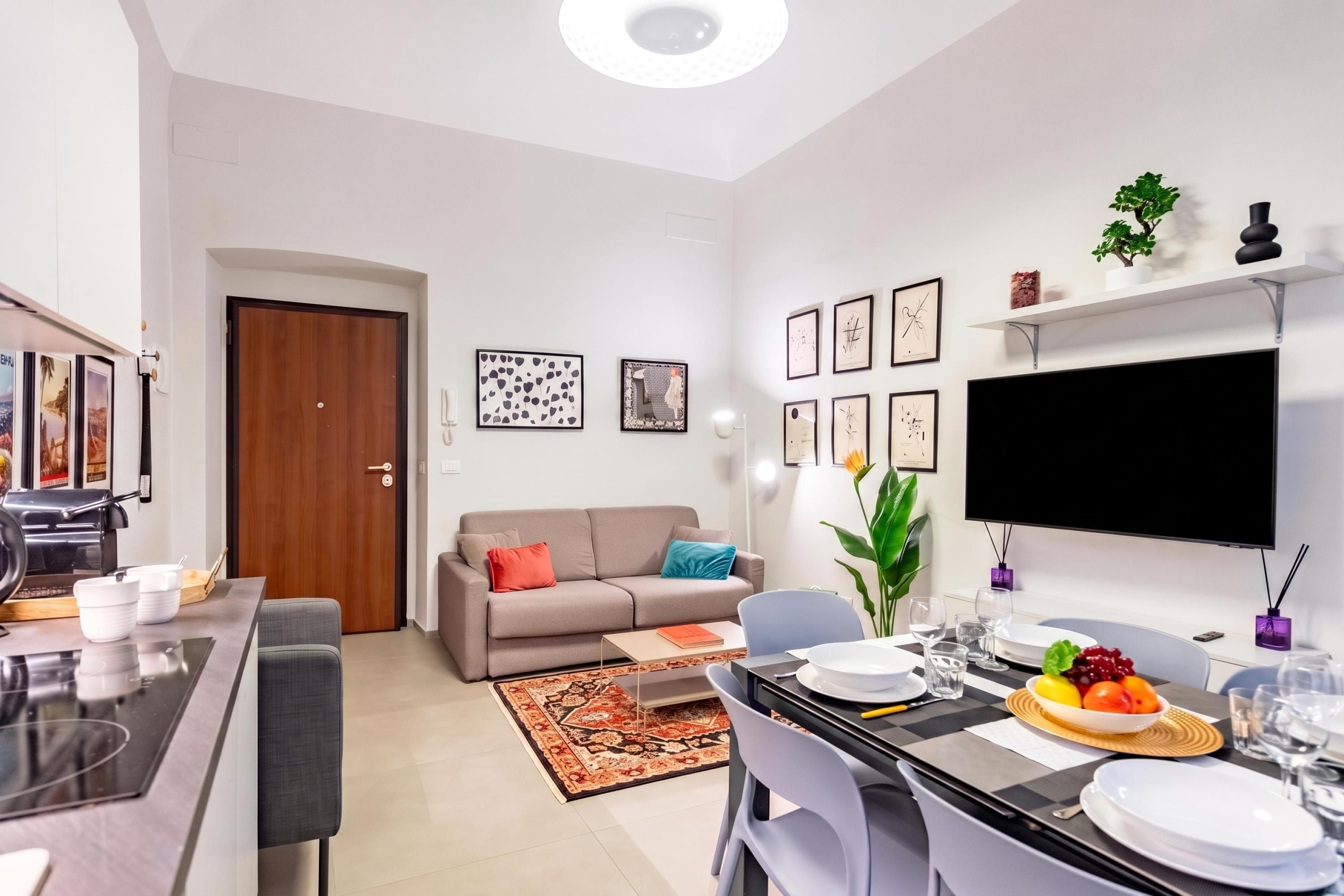Un salon moderne avec un canapé, une table basse et un coin repas comprenant des chaises et une table mise pour le repas.