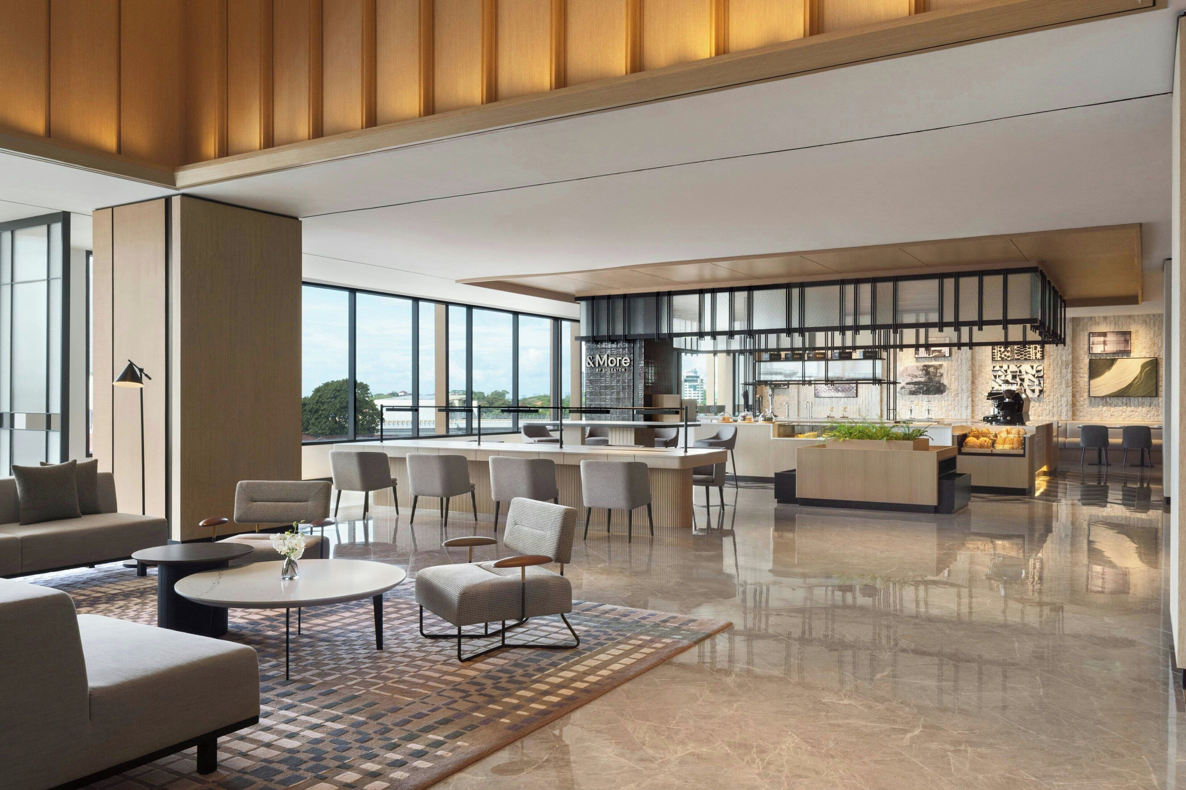 A spacious, modern living area with a kitchen and dining area, large windows, and a polished floor.