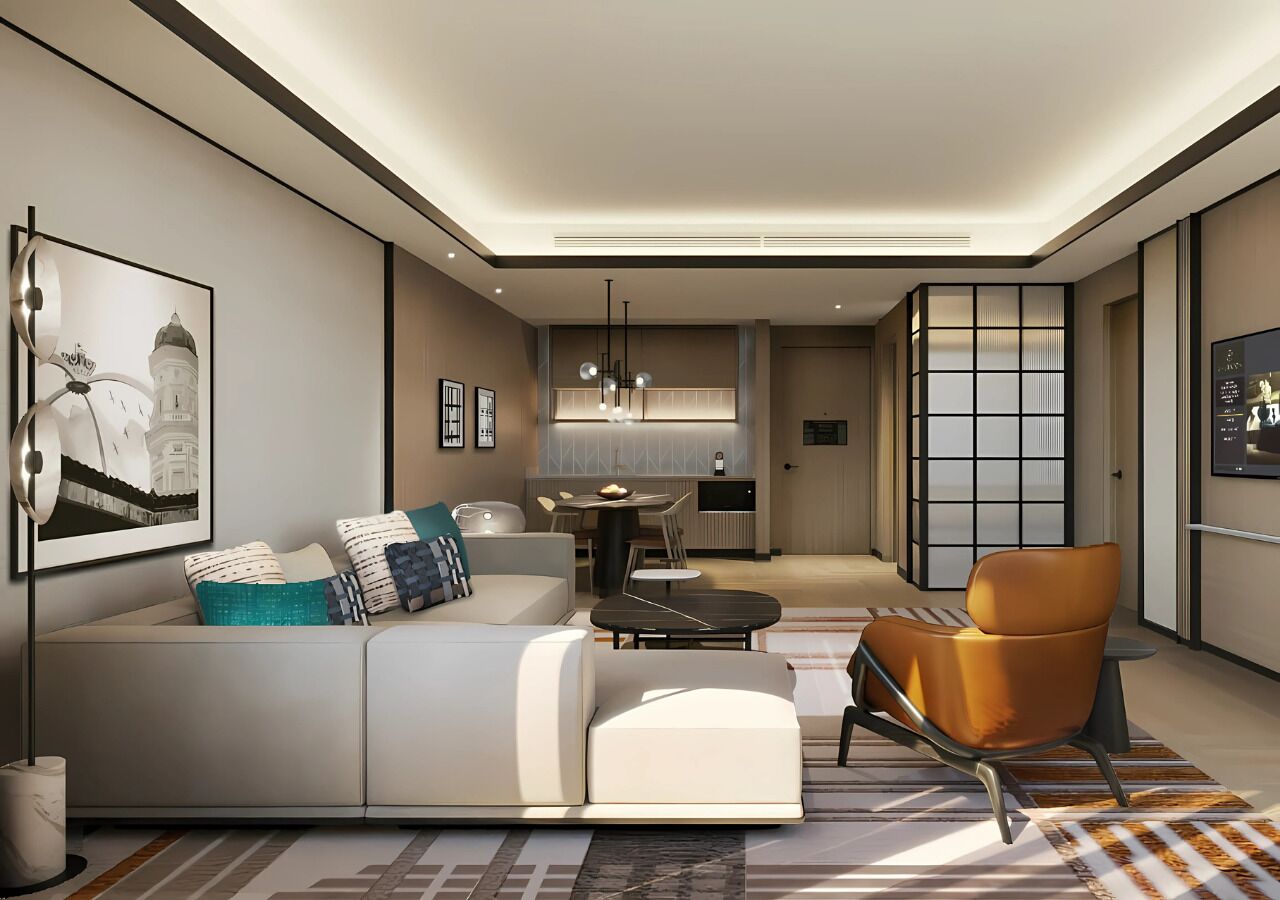 A modern living room with a sofa, a coffee table, and a chair. There is a dining area with a table and chairs in the background.