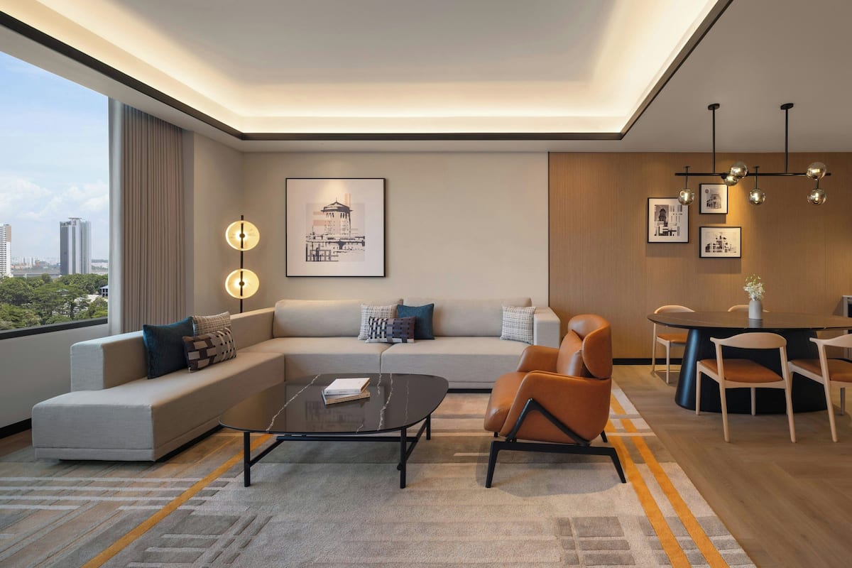 Un salon moderne avec un canapé, un fauteuil et une table basse. On y trouve également un coin repas avec une table et des chaises.