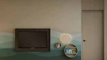 A wall-mounted television, a decorative shell, a small shelf with books, and a door.