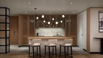 A modern kitchen with wooden cabinetry, a marble countertop, and three bar stools.