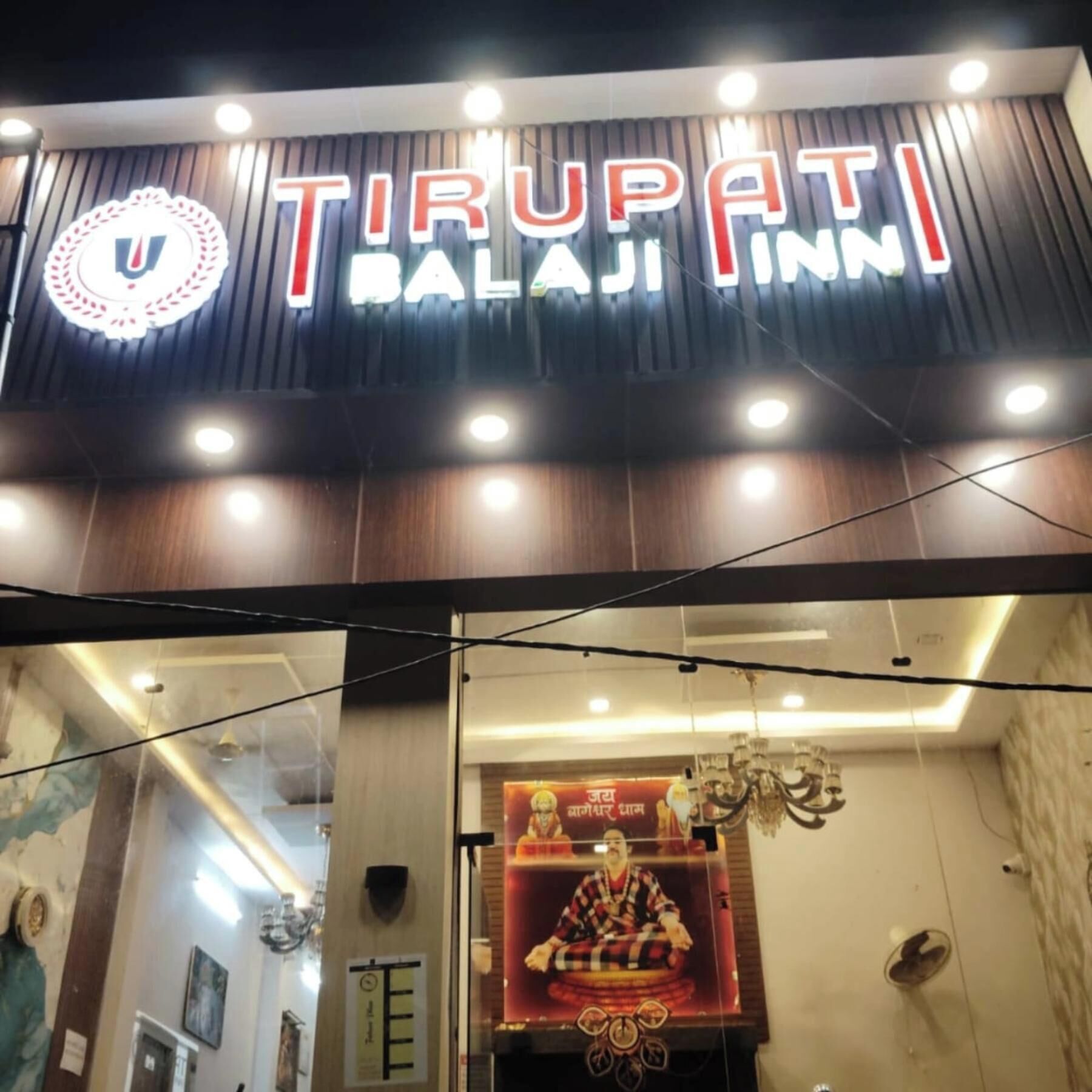A hotel entrance with a sign reading "TIRUPATI BALAJI INN".