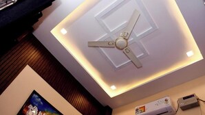 A ceiling fan with a central light fixture and recessed lighting. - Tirupati Balaji Inn Bageshwar Dham (Rajnagar)