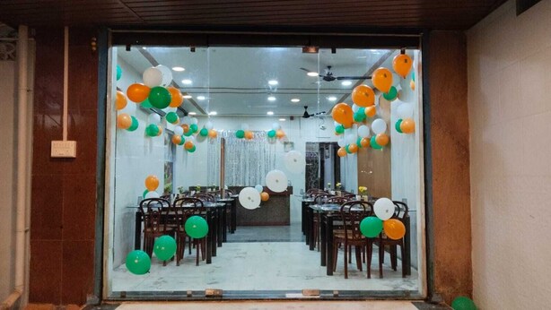 A dining area with tables and chairs, decorated with balloons. - AG Residency (Port Blair)