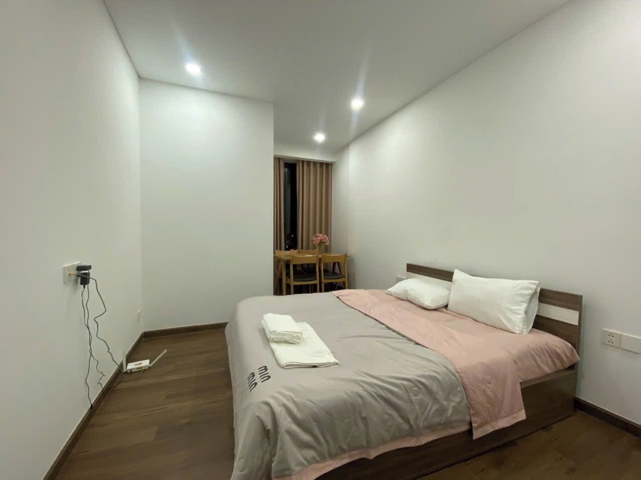 A bedroom with a bed, a desk, and a chair.