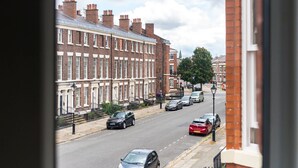 A street view with terraced houses, parked cars, and a clear sky. - Host Stay The Georgian Quarters at Bedford II and III (Liverpool)