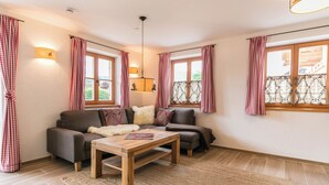 A cozy living room with a sofa set, a wooden coffee table, and a rug. - Vacation apartment Rehkitz (Reit im Winkl)