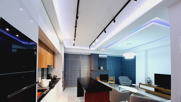 A modern kitchen with a black Bosch refrigerator, wooden cabinets, and a central island. - Bagebi two bedroom beautiful view  (Tbilisi)