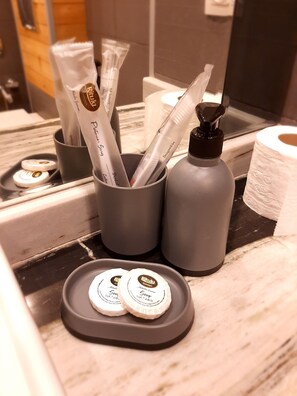 Bathroom amenities include a toothbrush holder, toiletries, and a roll of toilet paper.
