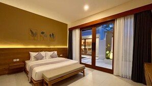 Un dormitorio moderno con una cama grande, cabecero de madera y vistas a un área exterior a través de una puerta corrediza de vidrio.