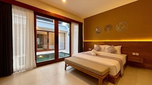 Un dormitorio amplio con una cama grande, un banco y vistas a una piscina a través de puertas de vidrio.