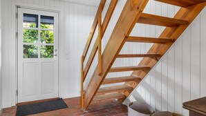 A wooden staircase in a room with white walls and a brick floor. - "Gravers" - 150m from the sea by Interhome (Svendborg)