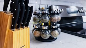 A kitchen with a knife block and spice jars.