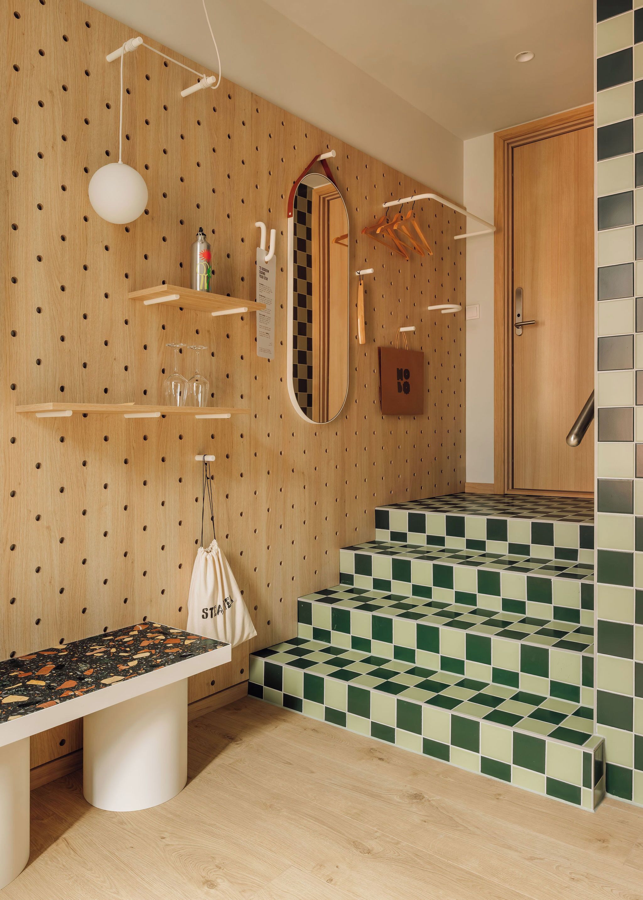 A modern bathroom with wooden paneling, a checkered tile floor, a mirror, and a countertop with a sink.