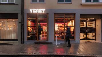 A storefront with a large illuminated sign reading "YEAST."