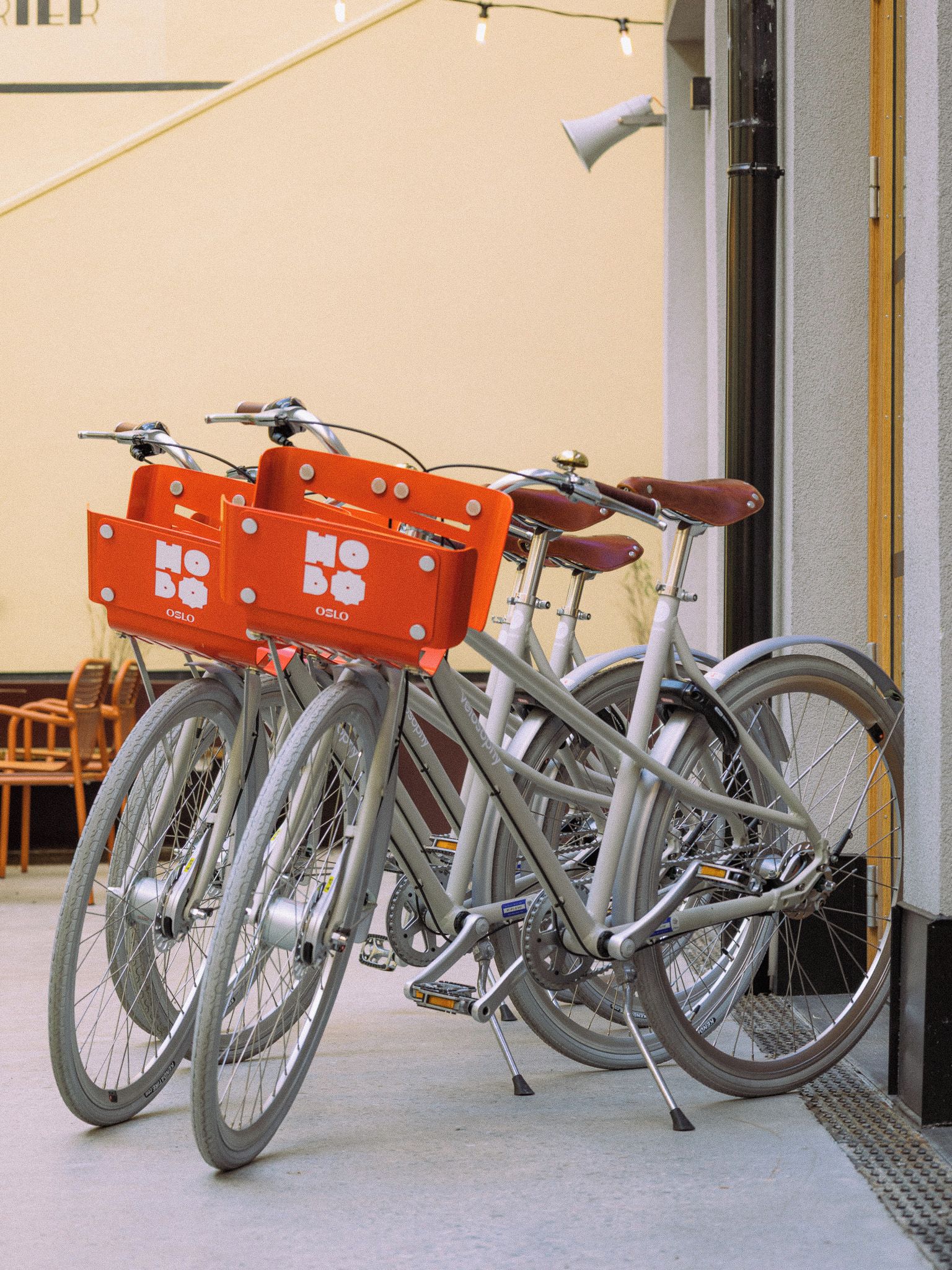 Een fiets met een bezorgdoos, geparkeerd voor een gebouw.