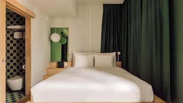 Ein modernes Schlafzimmer mit einem großen Bett, einem Holz-Kopfteil und einer grünen Akzentwand.