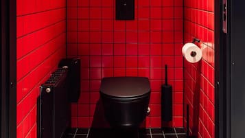 A red-tiled bathroom with a neon sign reading "DETTE ER OSLO" and a black toilet.