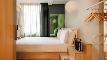 Un dormitorio moderno con cama, un escritorio de madera, una lámpara colgante y un armario con espejo.
