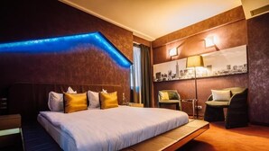 Une chambre d’hôtel moderne, dotée d’un grand lit, d’un bureau et d’une chaise.