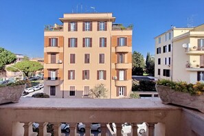 A multi-story residential building with balconies, a parking area, and surrounding greenery. - 4bnb - Monteverde Chic Comfort (Rome)