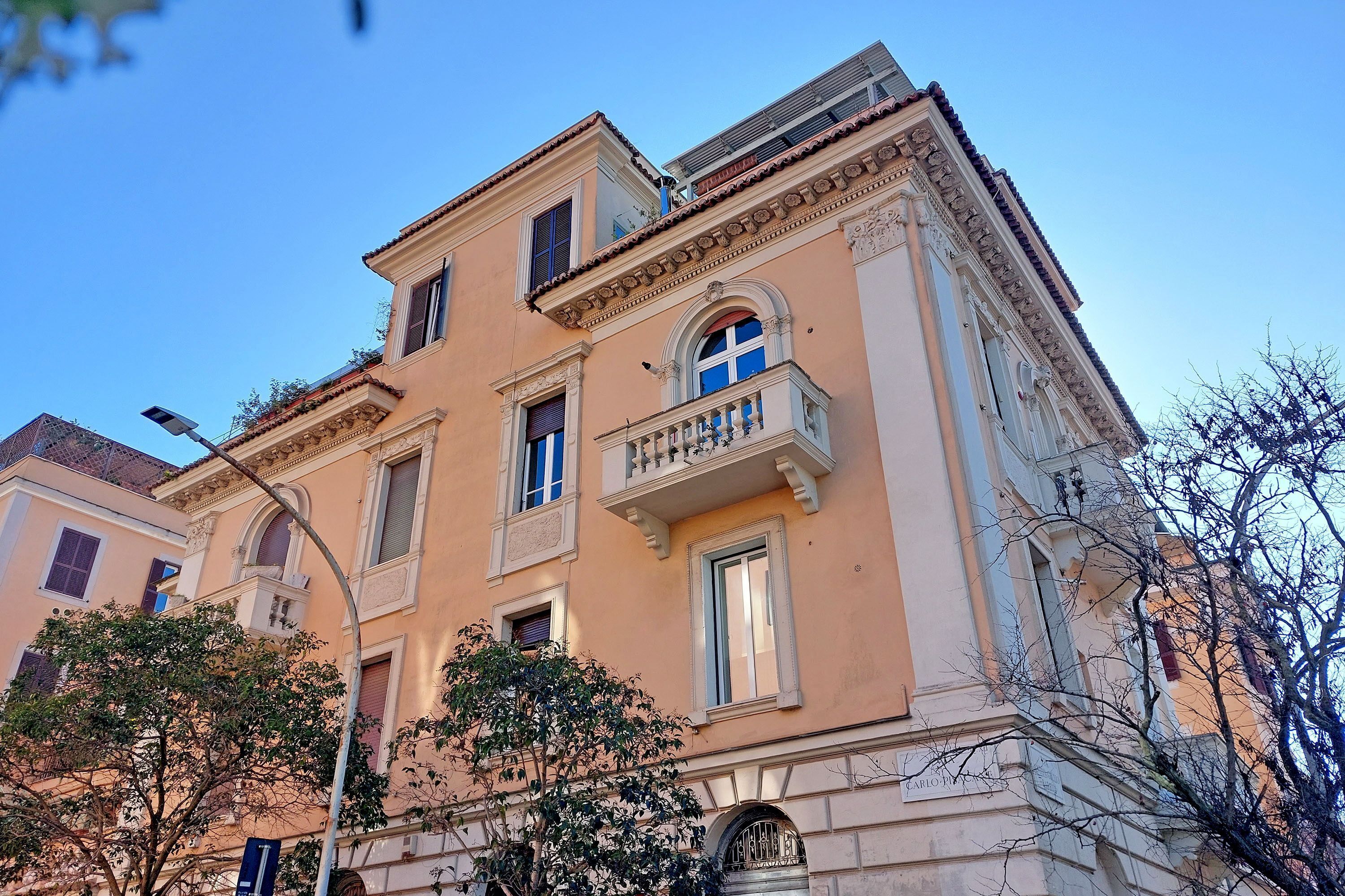 A multi-story building with classical architecture, featuring arched windows, balconies, and decorative moldings.