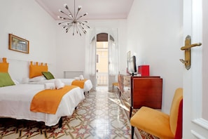 A hotel room with two beds, a dresser, a chair, and a decorative ceiling light. - 4bnb - Monteverde Chic Comfort (Rome)