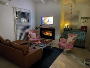 TV connectée, cheminée, livres, chaîne hi-fi