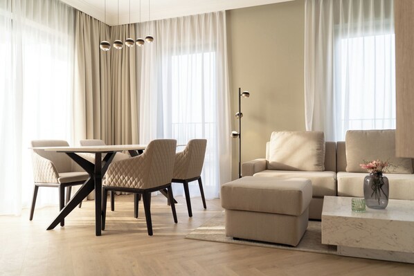 Un salon moderne comprenant une table à manger, des chaises, un canapé, une table basse et un lampadaire.