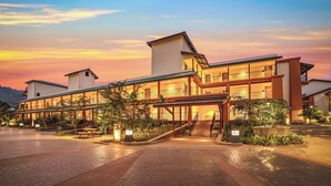 Ein modernes Hotel mit einem geräumigen Innenhof, mehreren Balkonen und einem gut beleuchteten Eingang.