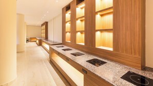 Una cocina moderna con armarios de madera, hornos empotrados y encimera de mármol.