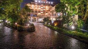 A hotel with a courtyard, paved pathways, and illuminated trees. - Club Mahindra Le Vintuna (Gangtok)