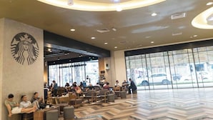 Una Starbucks con un interior moderno, área de estar y grandes ventanales.