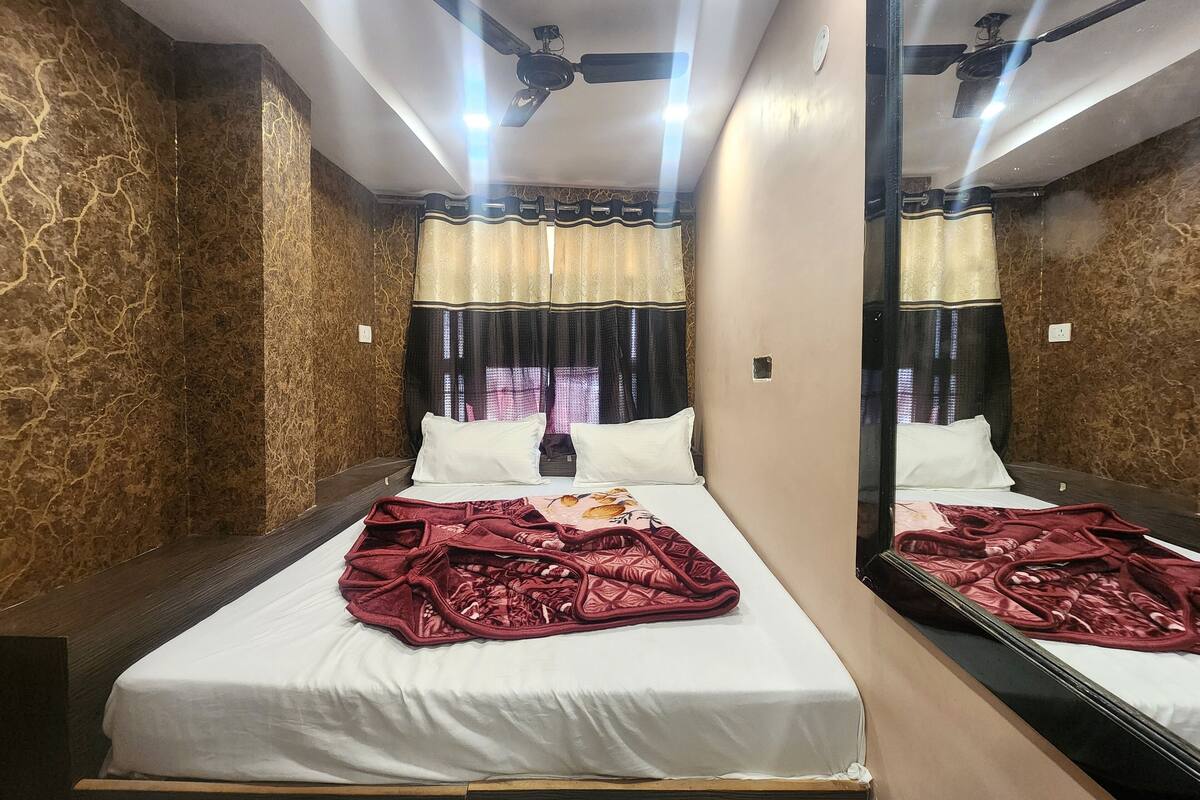 Ein Hotelzimmer mit Bett, Deckenventilator und großem Spiegel.