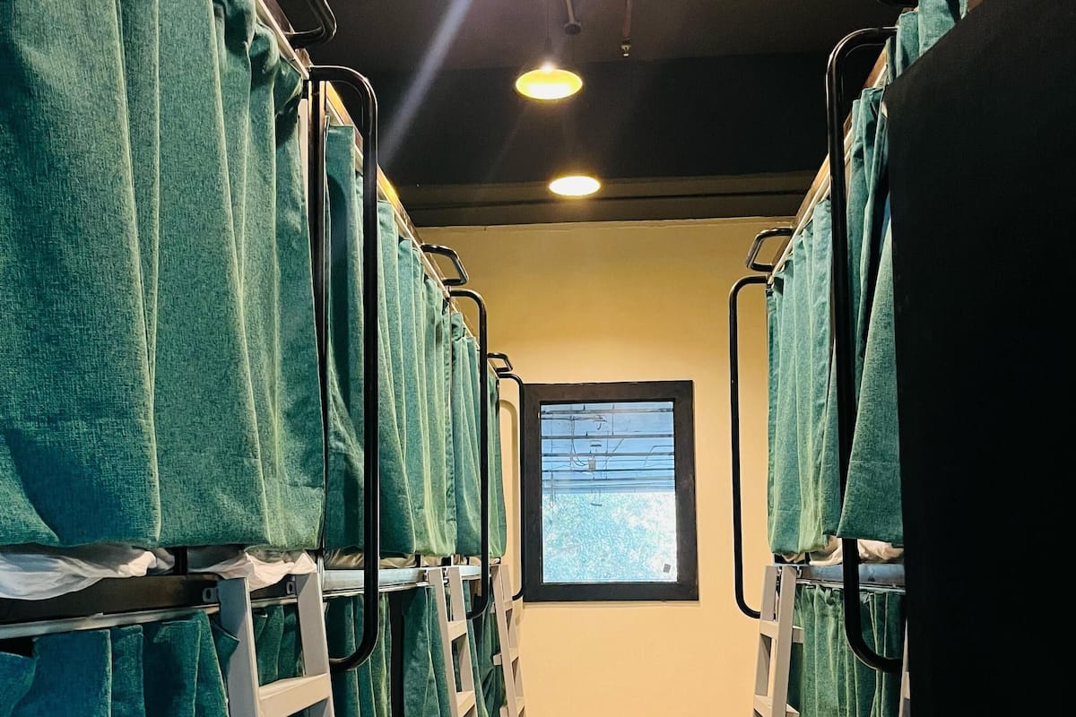 A corridor with bunk beds, a window with a view, and a screen displaying information.